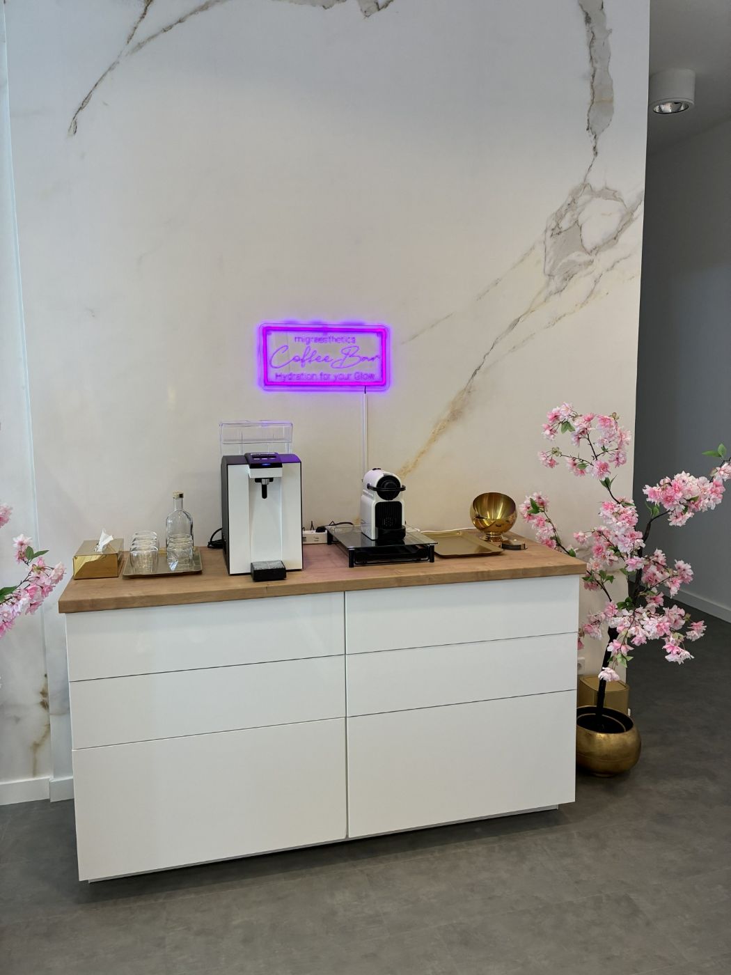 Coffee Bar vor Marmorwand mit Neonschild